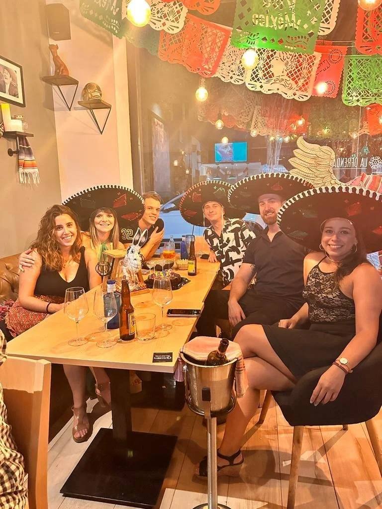 Clientes con sombreros de charro bajo el papel picado