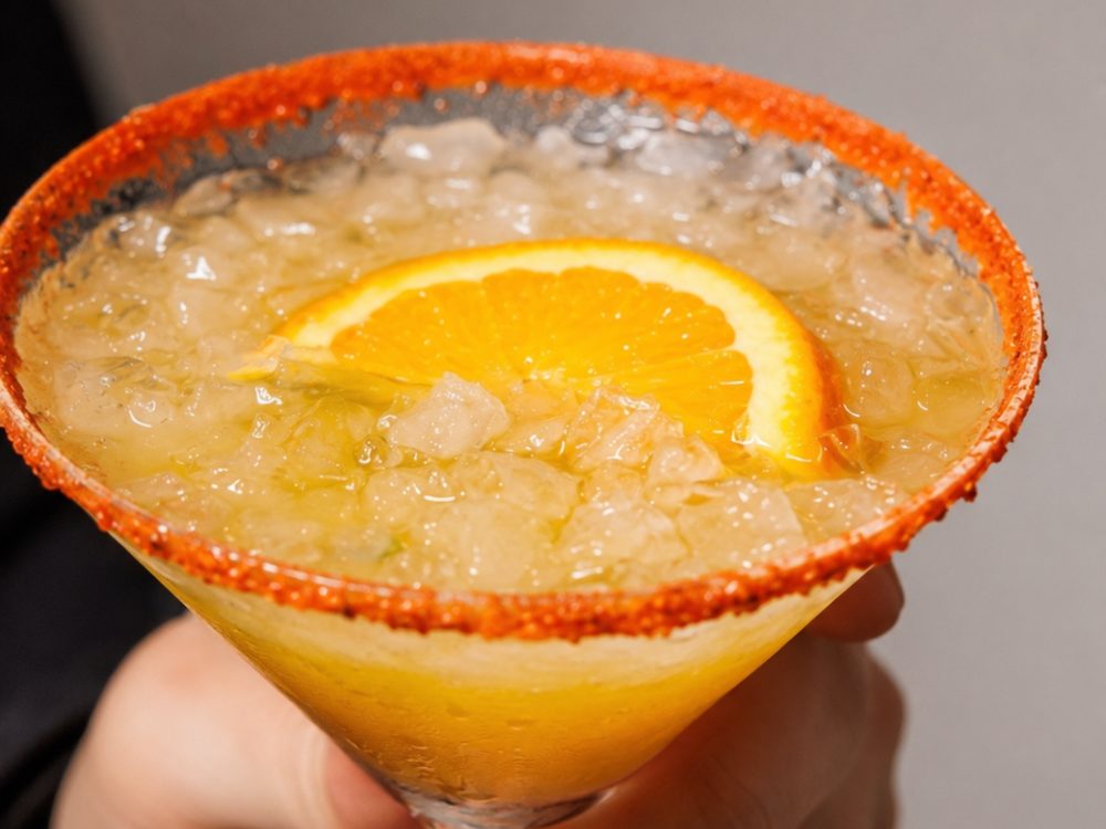 Margarita clásica con borde de chile y rodaja de naranja